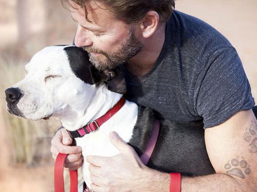 Homem a abraçar cachorro